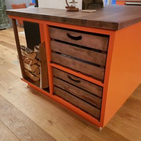 Oransje kjøkkenøy med rustikke skuffer og vedlagring